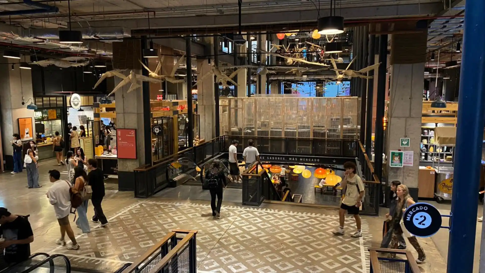 Pasillo de centro comercial con afluencia de visitantes